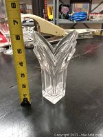 Front view showing the full height with measuring tape indicating about 7 inches tall, clear glass vase with a multi-pointed top design.