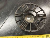 Top-down view showing Roman numeral clock face design of cast iron warmer trivet, highlighting circular shape and central recessed area.