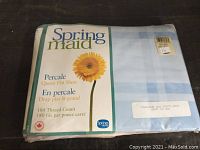 Front view of the original package, showing the Springmaid branding, percale weave, queen flat sheet size, 180 thread count, and light blue color with check pattern.