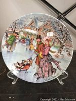 Front image of the Stewart Sherwood collector plate depicting a winter ice skating scene with a Victorian couple and sled in detailed festive setting.