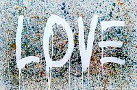 Close-up of center of canvas showing white 'LOVE' text and multicolor paint splatter background