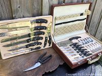 Photo of vintage 22-piece Solingen cutting utensil set in original packaging, showing various knives, forks, cleaver, scissors, and briefcase exterior.