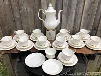 Full set arranged showing coffee pot, cups, saucers, bread plates