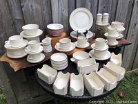 Full set of vintage Steelite England burgundy rimmed dinnerware displayed on a table outdoors with all items visible including plates, bowls, cups, saucers, sauce jug, condiment bowls, and shakers.