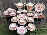 Full set arranged showing coffee pot, teapot, cups, saucers, plates, covered sugar, creamer, and tray.