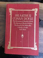 Front cover of the illustrated Sherlock Holmes treasury book showing red hardcover with gold embossed title and decorative border.