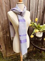 Lilac wool wrap with purple stripes displayed on mannequin showing length and fringe