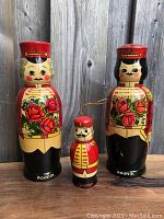 Front view of all three Matryoshka dolls showing detailed faces and floral patterns on the two larger Rodnik dolls with smaller Gromoff doll in center.