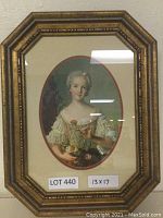 Full view of the framed print showing the full oval portrait of a woman holding flowers in period clothing, surrounded by a double mat and gold-tone decorative frame.