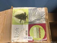Photo of the original packaging box showing the brand 'Martha Stewart Everyday' and the size '4 1/2 ft' with an image of the fully decorated artificial tree.