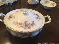 Side view of the covered serving bowl showing floral pattern, gold trim, and ornate handles.