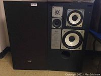 Pair of speakers side by side, one with grille panel on left and drivers exposed on right