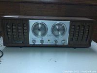 Front view of the Strauss radio showing the wood case with speaker grills and control panel with dials and knobs.
