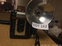 Front view of Argus Argoflex Seventy-Five vintage camera and attached flash unit, showing lens and flash reflector.