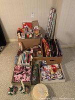 Wide view of all items showing candles, floral arrangements, wrapping paper rolls, gift bags, ribbons, tape, and a decorative wine gift tube