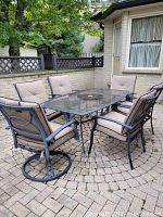 Full patio set from side angle showing table and all six chairs on paved surface.