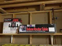 Boxes for Skil plunge router and Iron Horse deluxe router table on a workshop shelf.