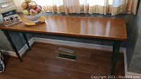Full view of wooden console table with bowl and birdhouse on top