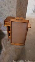 Wood calendar holder with heart cutout details resting against the side table on carpeted floor.