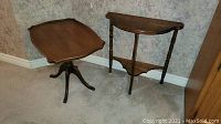 Photo showing both wood tables: demi lune table with lower shelf and wood pedestal tray table.