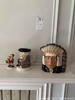 Overall front view showing the three items on a shelf: two Toby jugs and two children figurines.