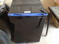 Closed black Insignia compact refrigerator with blue trim handle, showing external condition.