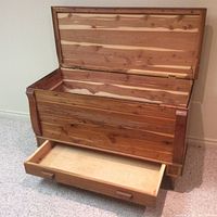 Open cedar lined blanket box showing interior and drawer pulled out in front.