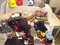 Wide shot showing assortment of hats, scarves, gloves, pillows, and slippers on display.