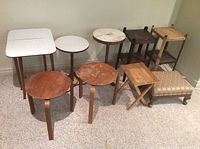 Photo of the full set showing variety of side tables, plant stands, folding table, and foot stool arranged against wall