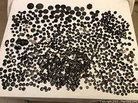 Wide layout of predominantly black buttons in various sizes and styles spread across a white surface