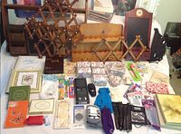 Photo of the full lot showing wooden wall hangers, spice racks, floral trinket boxes, various albums, journals, purses, gloves, and small packaged goods.