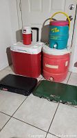 Overview of all coolers and two outdoor Coleman stoves, showing their size, color and arrangement
