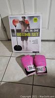 Boxed all-in-one boxing set with punch ball and pink boxing gloves in foreground.