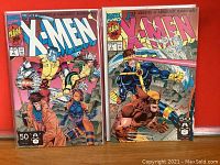 X-Men Comic Book Issue #7 and #1 standing upright showing vibrant cover artwork.