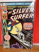 Front cover of the Marvel comic featuring The Silver Surfer and Spider-Man in dynamic poses with the comic title and text about the 'Strange Death of Adam Warlock'.
