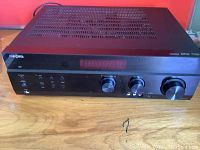 Front left angle view of Insignia stereo receiver showing digital display, knobs, and buttons.