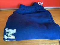 Photo of blue track pants folded showing elastic waistband and part logo