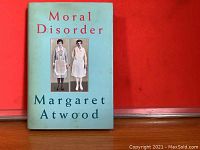 Front cover of the hardcover book showing title, author and image of two women on blue background.