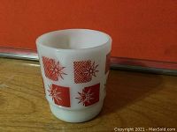 Front angle view of white vintage glass mug featuring red psychedelic geometric star and square design