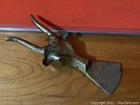 Close-up of solid brass longhorn door stop detailing horns and textured base