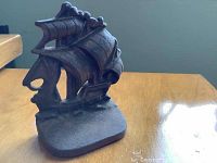 Angle view of solid brass schooner doorstop showing detailed sails and hull