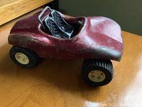 Red Tonka tin toy dune buggy with visible scratches on metal body and black interior seating.