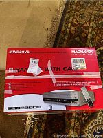 Front view of the original red Magnavox box showing the model MWR20V6 and product image of the DVD/VHS combo player with remote control.