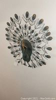 Full view of metal peacock wall art displaying spread tail feathers