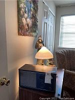 Image showing Concord RAF10 radiocorder radio with speaker, analog dials, and control knobs on a wooden case beside a lamp and figurines.