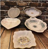 Six vintage ceramic decorative dishes displayed against brick background including Royal commemorative trinket dish with Prince Charles and Lady Diana portraits.