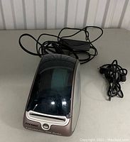 Closed Dymo LabelWriter 400 Turbo label maker with power cords on table.