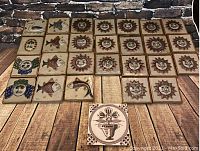 Lot of 27 hand-painted vintage Mexican ceramic tiles arranged showing various designs including suns, fish, owls, and one plant tile.