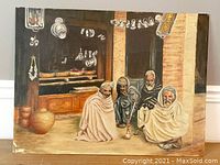Front view of the oil painting depicting four Arab men sitting and smoking a hookah in a market environment