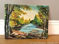 Front view of the landscape oil painting showing river flowing between tree-lined banks with rocks in foreground.